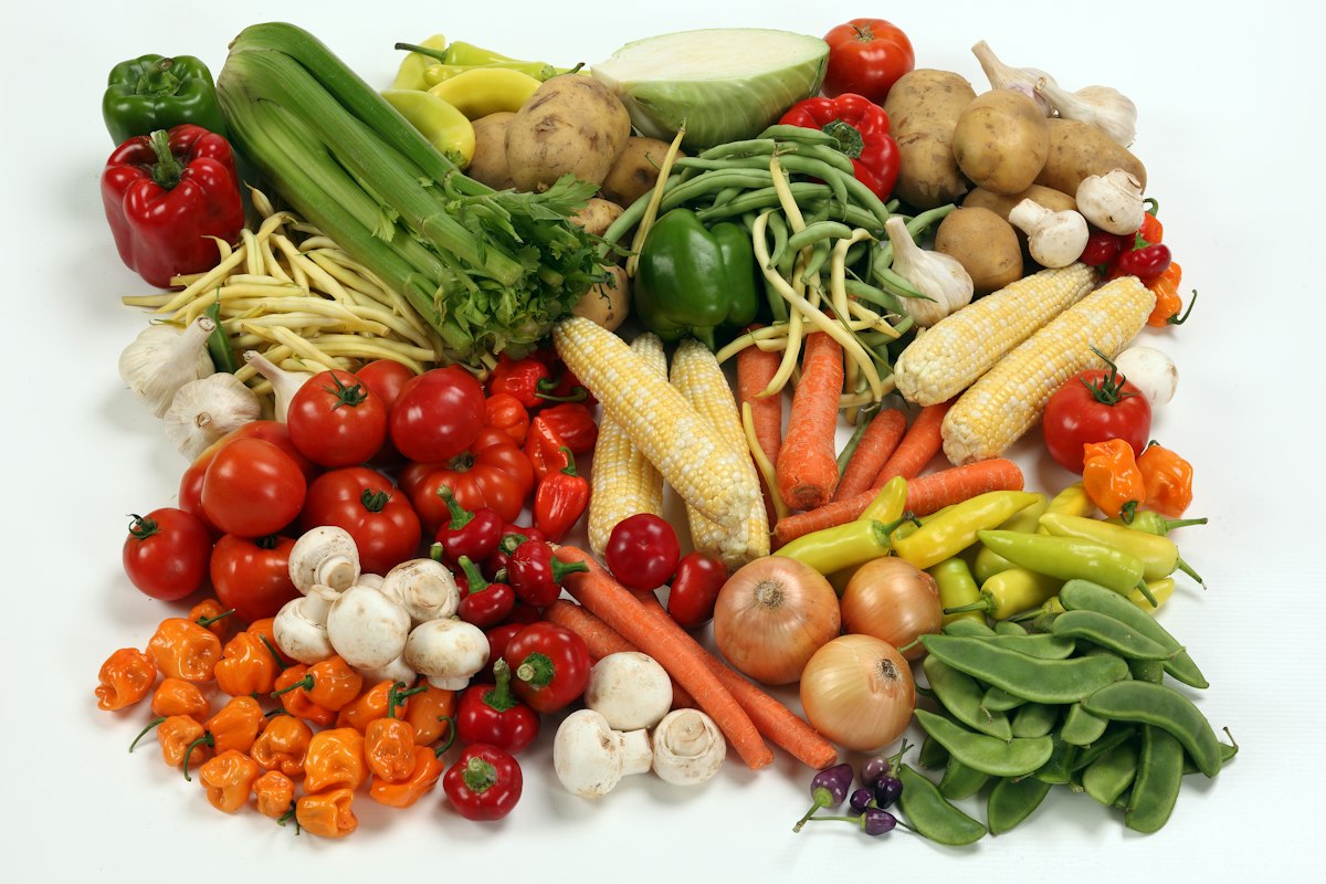 Colorful vegetable salad bowl with fresh greens, tomatoes and olive oil dressing